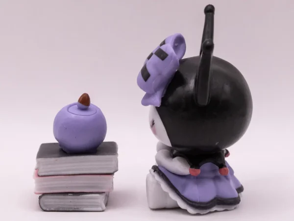 Figurine de collection Kuromi assise sur une pile de livres