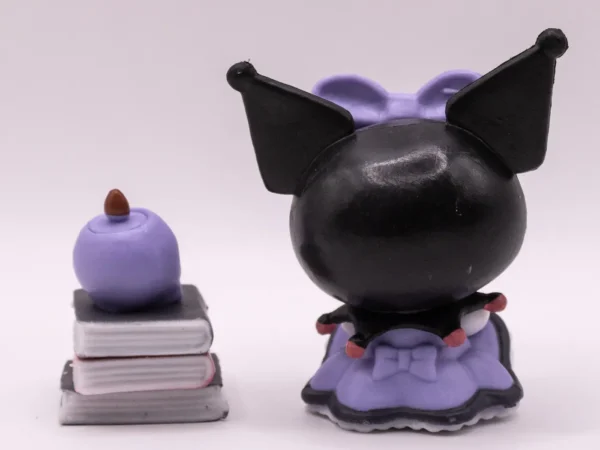 Figurine de collection Kuromi assise sur une pile de livres