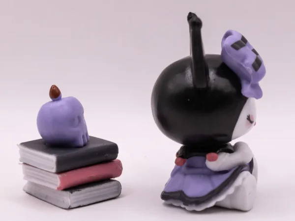 Figurine de collection Kuromi assise sur une pile de livres