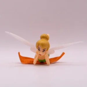 Petite fée en plastique vert sur une feuille décorative
